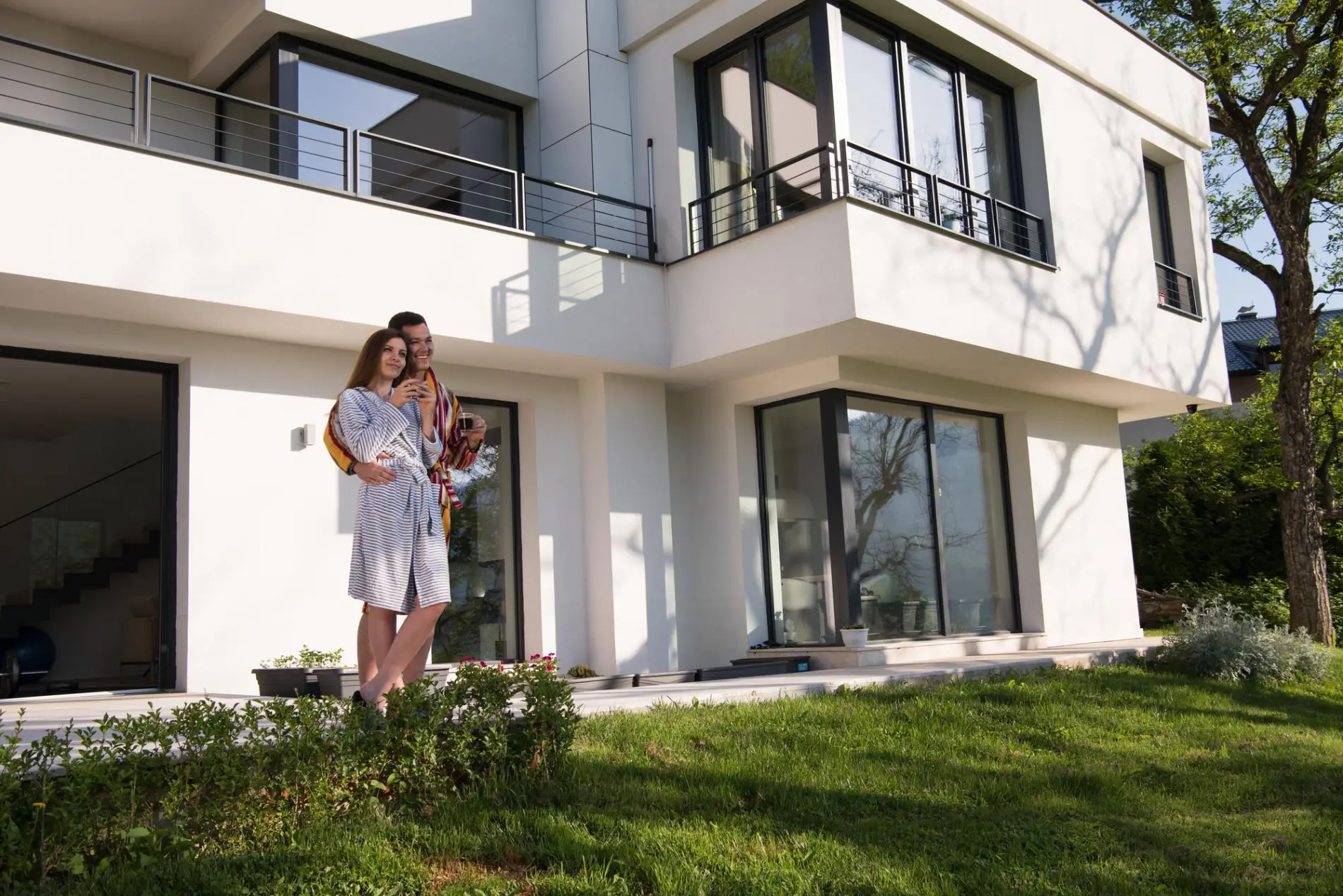 Clients souriant devant leur maison à Créon après les travaux de ravalement de façade.
